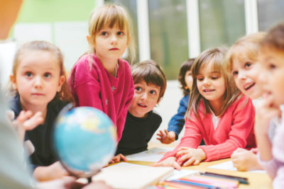 Children in classroom learning about the world